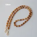 Vue détaillée de la bandoulière en perles acryliques caramel de 120 cm avec fermoirs dorés. - 120cm / Couleur caramel