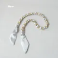 Détail de la bandoulière chaîne dorée de 60 cm entrelacée de ruban de soie bleu clair - Gris (Quincaillerie Or)