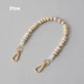 Detail view of a marbled acrylic beaded strap with golden metal clasps, 37cm in length - Beige