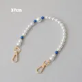 Detailed macro view of 37cm pearl and blue bead chain strap with gold metal clasps - 37cm / Blue