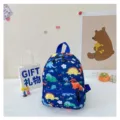 Cute navy blue children's backpack featuring colorful dinosaur patterns in a lifestyle setting - Dinosaur Print / Blue