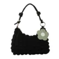 Stylish black ruched shoulder bag featuring knotted strap and a green flower charm accessory - Black