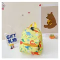 Detailed view of yellow toddler backpack with colorful cartoon dinosaur prints - Dinosaur Print / Yellow