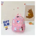 Cute pink children's backpack with unicorn patterns in a cozy gift setting - Unicorn Print / Pink