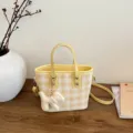 Yellow and white gingham bucket bag with a cute white dog charm on a wooden table - With Pendant / Yellow
