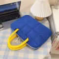 Borsa per laptop blu trapuntata con manici gialli in una scena di stile di vita - Grande / Blu