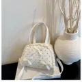 Elegante bolso blanco de lunares con adornos de encaje y lazos sobre un libro. - S / Blanco