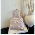 Detalle de bolso rosa de lunares con adornos de encaje crema y lazos decorativos - S / Rosa