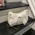 Chic white bubble gauze underarm bag featuring a large satin bow and silver chain strap. - White