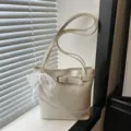 Grande borsa a secchiello crema con dettaglio cintura e ciondolo fiocco in pizzo - con portachiavi / Bianco avorio