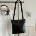 Moderna borsa a secchiello sottobraccio nera lucida con dettaglio fibbia decorativa - senza ciondolo / Nero