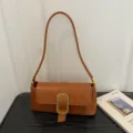 Elegant brown baguette shoulder bag with crocodile texture and gold buckle detail - Brown