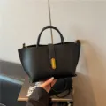 Bolso tote minimalista de piel granulada negra con detalles dorados - Negro