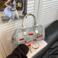 Stylish embroidered cherry denim Boston handbag with silver top handles and crossbody strap - No Pendant / Silver