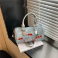 Stylish denim Boston bag featuring red cherry embroidery and metallic silver handles. - No Pendant / Blue