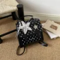 Stylish black and white polka dot backpack with metallic star charms for women. - Black with Charm