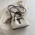 Vintage style cream fabric bucket bag with brown leather handles and a cute bear charm - White
