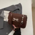 Modische braune Umhängetasche mit einer funkelnden Kristallschleife und Kettenriemen - Braun