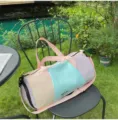 Pastel color block duffel travel bag outdoor lifestyle detail showing large capacity design. - Pink