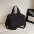 Black large capacity travel duffel bag with shoulder strap and front pocket storage. - Black