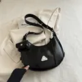 Black moto-style leather crescent hobo bag with detachable pouch and metal triangle - Black