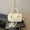 Stylish off-white leather bowling pillow bag with top handle and crossbody strap - No Pendant / White
