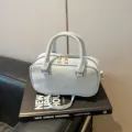 Light blue bowling style pillow bag with top handles and adjustable crossbody strap - No Pendant / Blue
