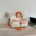 Large capacity canvas travel duffel bag with vibrant orange handles and multiple pockets. - Off White