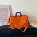 Orange large capacity travel duffel bag with blue handles, portable weekend sports bag. - Orange