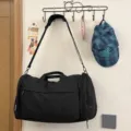 Large capacity black travel duffel bag with shoulder strap, ideal for trips and gym use. - Black