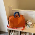 Orange large capacity travel duffel bag with blue handles, lightweight gym and sport bag. - Orange