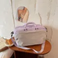 Lavendelfarbene Reisetasche mit Schuhfach, stilvolles Lifestyle-Detailfoto auf Holztisch. - Hellviolett