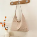 Fashionable beige suede-textured hobo shoulder bag featuring elegant gold stud embellishments - Beige
