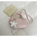 Detailansicht der rosa Boston-Handtasche mit silbernem Sternanhänger und Prägelogo - Mit Anhänger / Rosa