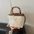 Handgefertigte gewebte Stroh-Eimertasche mit Bambusgriffen und Spitzen-Perlen-Schleife - Cremeweiß mit Anhänger