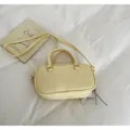 Elegant cream-colored Boston bowling bag with top handles and adjustable cross-body strap - No Pendant / Yellow