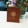 Biglietto di Natale a quadri marroni con fiocco di neve dorato e scritta - Stile Fiocco di Neve / 1 Biglietto Con 1 Busta