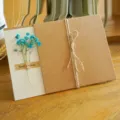 Biglietto di auguri vintage in carta kraft con fiori secchi blu e fiocco in spago - Gipsofila Blu (Fiore Secco)