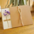 Biglietto d'auguri vintage in carta kraft con fiori secchi viola e fiocco in spago. - Gipsofila Viola (Fiore Secco)