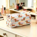 Detailed view of dachshund pattern cosmetic bag on a professional vanity makeup table - Style 03 / L