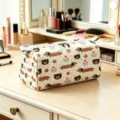 Detailed view of cosmetic bag with cute dachshund and cupcake prints on a vanity - Style 02 / L
