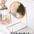 Brass tabletop cosmetic makeup mirror with rotating round frame, elegant desktop vanity design. - Gold