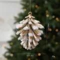 Gouden dennenappel kerstboomversiering met sneeuwdetail 10x7cm - Goud