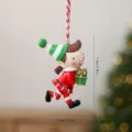 Festive resin Christmas elf ornament holding a green gift box for tree hanging - Elf