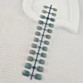 Detail view of short square false nails with cat eye grey green finish on strip holder. - 24 Pcs/Set / Brownish Green