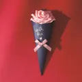 Rosa artificiale rosa in confezione di carta a forma di cono blu per bomboniere. - Fiore rosa con fiocco rosa / Lungo circa 21,5 cm / Blu scuro