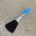 Nahaufnahme der kleinen Reinigungsbürste mit weichen schwarzen Borsten und blauem Griff. - Blau
