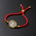Detailed view of red braided cotton rope bracelet with vintage gold-tone pendant - Bracelet / Red