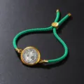 Close-up view of a green twisted cotton rope bracelet with a gold circular pendant. - Bracelet / Green