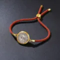 Detail of an adjustable orange braided rope bracelet with a gold vintage medal pendant - Bracelet / Brown